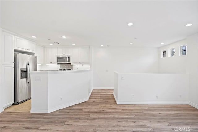 80 Hedge Bloom, Irvine, CA 92618 - kitchen featuring stainless steel appliances, light wood-style flooring, white cabinetry, recessed lighting, and a peninsula