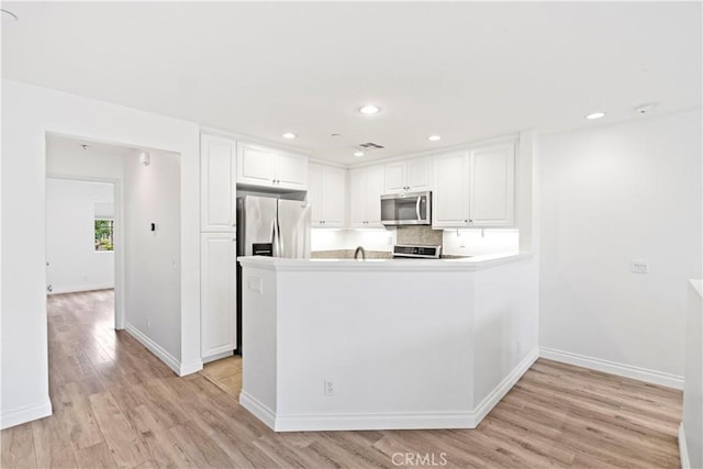 80 Hedge Bloom, Irvine, CA 92618 - kitchen featuring appliances with stainless steel finishes, light wood finished floors, white cabinets, a peninsula, and light countertops