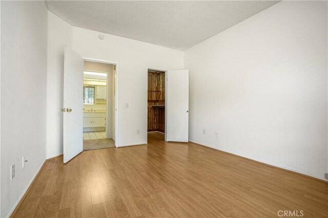 33 Abrazo Aisle Unit 174, Irvine, CA 92614 - unfurnished bedroom with light wood-style flooring and connected bathroom