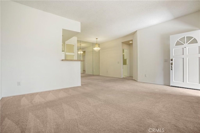 33 Abrazo Aisle Unit 174, Irvine, CA 92614 - unfurnished living room with light carpet, a textured ceiling, and a chandelier