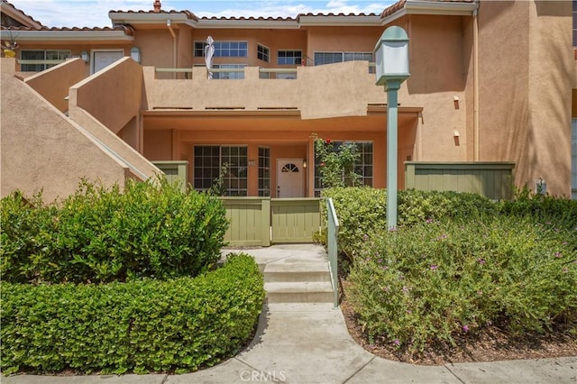 33 Abrazo Aisle Unit 174, Irvine, CA 92614 - doorway to property featuring a balcony and stucco siding