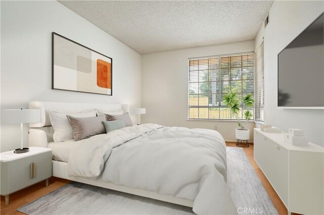 33 Abrazo Aisle Unit 174, Irvine, CA 92614 - bedroom featuring light wood-style flooring and a textured ceiling