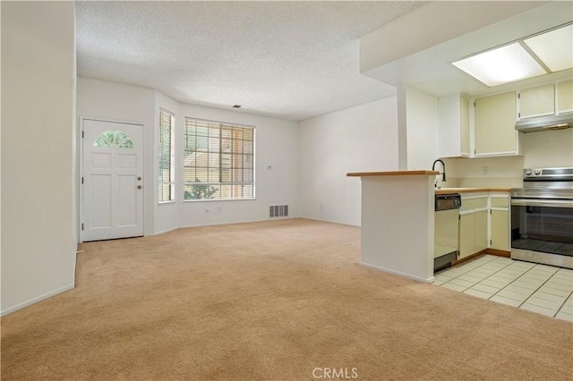 33 Abrazo Aisle Unit 174, Irvine, CA 92614 - kitchen featuring stainless steel range with electric stovetop, light carpet, dishwasher, a peninsula, and light countertops