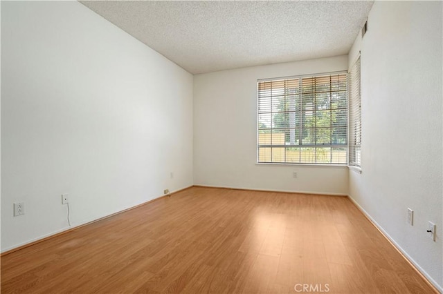 33 Abrazo Aisle Unit 174, Irvine, CA 92614 - empty room with light wood-type flooring and a textured ceiling