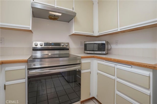 33 Abrazo Aisle Unit 174, Irvine, CA 92614 - kitchen featuring appliances with stainless steel finishes, under cabinet range hood, light tile patterned floors, and tile counters