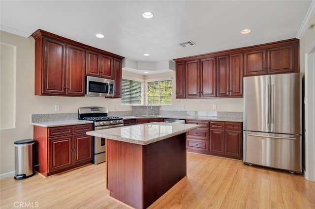 17450 Devonshire St, Northridge, CA 91325 - kitchen with stainless steel appliances, light wood-style flooring, recessed lighting, a kitchen island, and ornamental molding