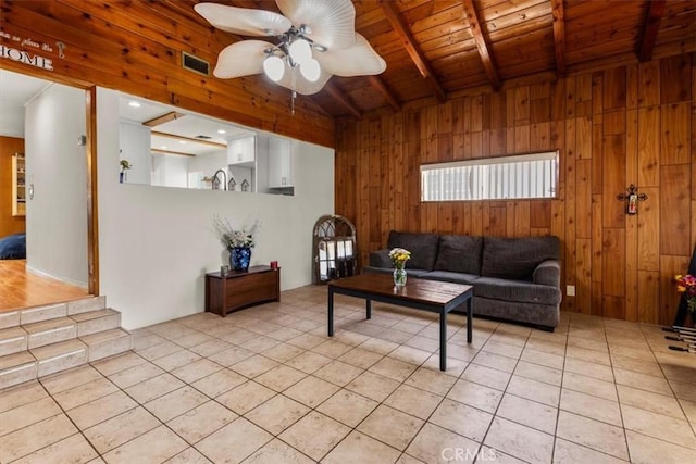 12727 Lefloss Ave, Norwalk, CA 90650 - living room with wooden walls, a wood ceiling with exposed beams, ceiling fan, and light tile patterned floors