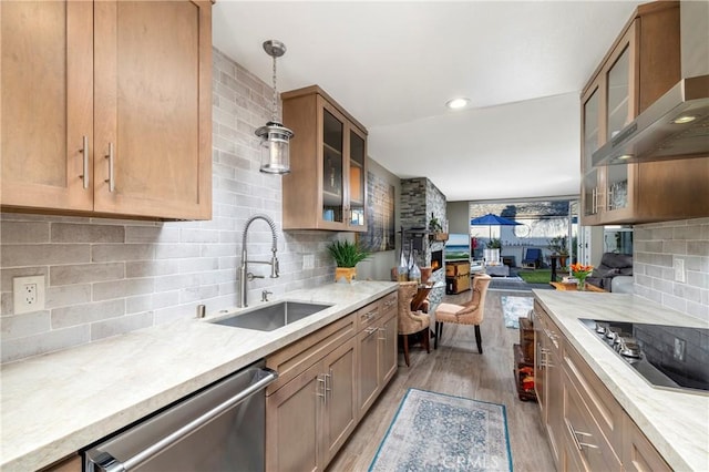 16520 Harbour Ln Unit 6, Huntington Beach, CA 92649 - kitchen with wall chimney range hood, dishwasher, a lit fireplace, and black electric cooktop