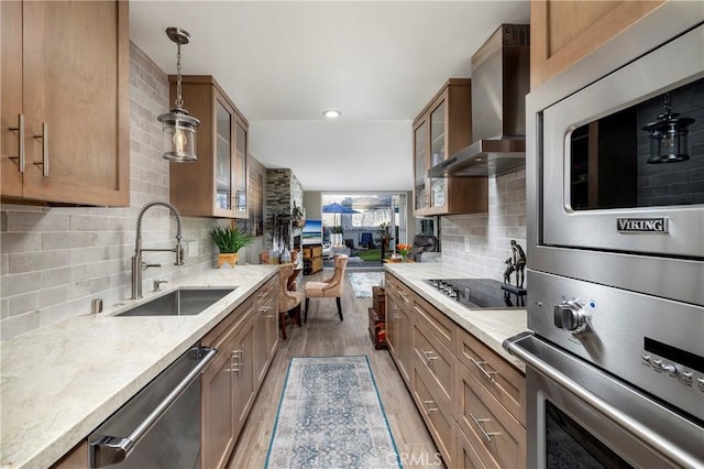 16520 Harbour Ln Unit 6, Huntington Beach, CA 92649 - kitchen with wall chimney range hood, appliances with stainless steel finishes, light wood-style flooring, decorative light fixtures, and tasteful backsplash