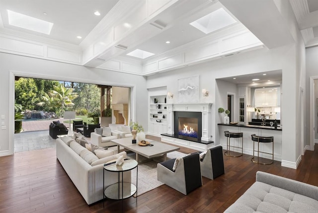17324 Calle Serena, Rancho Santa Fe, CA 92067 - living room with a skylight, dark wood-style flooring, a warm lit fireplace, built in shelves, and recessed lighting