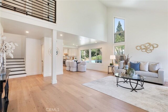 21679 Calle Alcazar, Yorba Linda, CA 92887 - living room featuring stairway, a towering ceiling, light wood finished floors, and recessed lighting