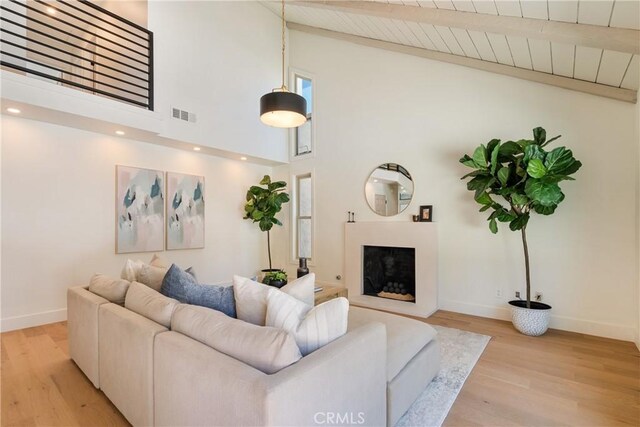 21679 Calle Alcazar, Yorba Linda, CA 92887 - living room featuring light wood-style floors, high vaulted ceiling, a fireplace with raised hearth, and a wood ceiling with exposed beams
