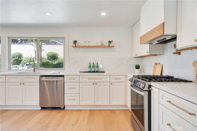 21679 Calle Alcazar, Yorba Linda, CA 92887 - kitchen featuring appliances with stainless steel finishes, light countertops, custom range hood, white cabinets, and tasteful backsplash