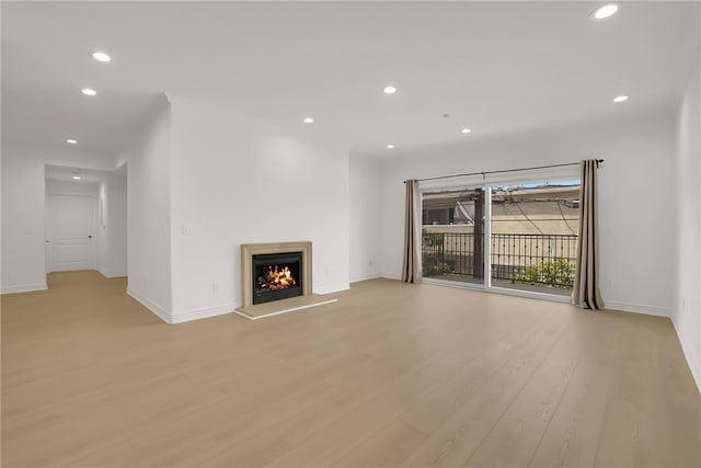 8555 Cashio St Unit 203, Los Angeles, CA 90035 - unfurnished living room with recessed lighting, light wood finished floors, and a warm lit fireplace
