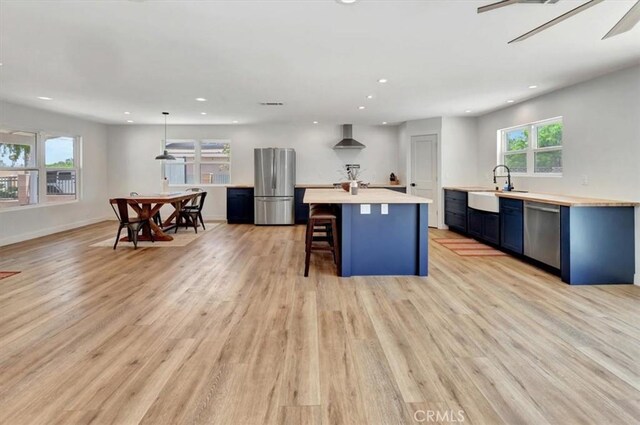 1500 Pacific Ave, Norco, CA 92860 - kitchen with stainless steel appliances, light countertops, recessed lighting, light wood-style flooring, and a breakfast bar area