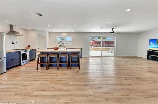 1500 Pacific Ave, Norco, CA 92860 - kitchen with wall chimney range hood, stainless steel appliances, light wood-type flooring, recessed lighting, and light countertops