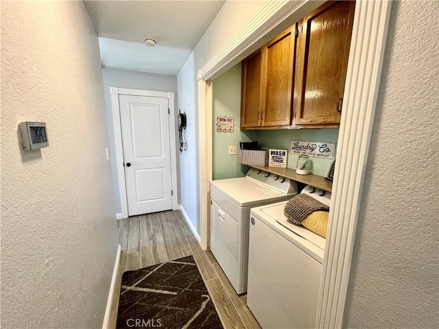 3332 Shamrock Pl, Merced, CA 95340 - laundry room featuring cabinet space, washing machine and dryer, a textured wall, and light wood-type flooring