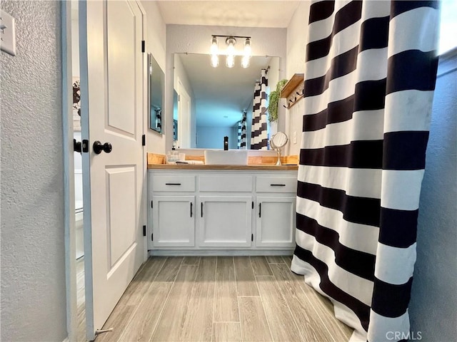 3332 Shamrock Pl, Merced, CA 95340 - full bathroom featuring wood finished floors, a textured wall, vanity, and a shower with curtain