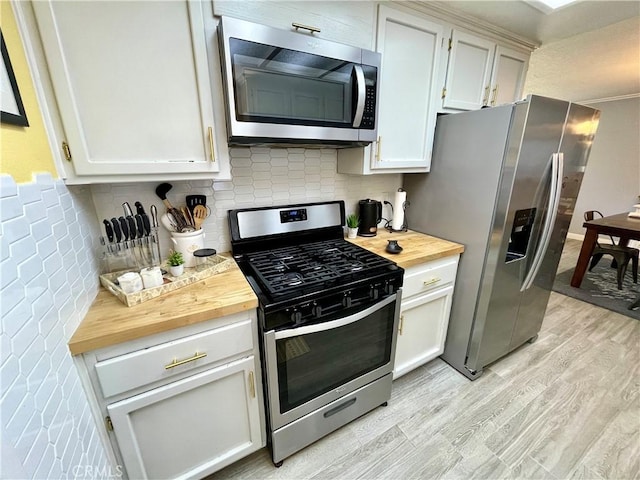 3332 Shamrock Pl, Merced, CA 95340 - kitchen with appliances with stainless steel finishes, butcher block counters, light wood-type flooring, tasteful backsplash, and white cabinetry