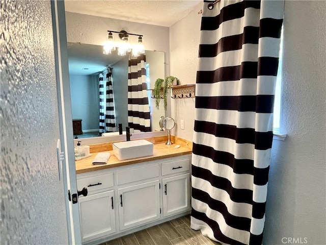 3332 Shamrock Pl, Merced, CA 95340 - bathroom with a textured wall, vanity, a shower with shower curtain, and wood finished floors