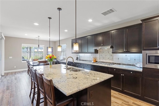 44655 Howell Mountain St, Temecula, CA 92592 - kitchen featuring appliances with stainless steel finishes, light stone countertops, a breakfast bar, light wood-type flooring, and recessed lighting