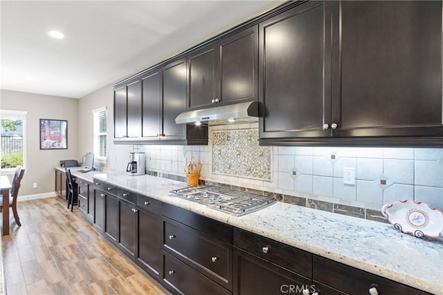 44655 Howell Mountain St, Temecula, CA 92592 - kitchen featuring under cabinet range hood, stainless steel gas stovetop, light wood-style flooring, light stone countertops, and backsplash