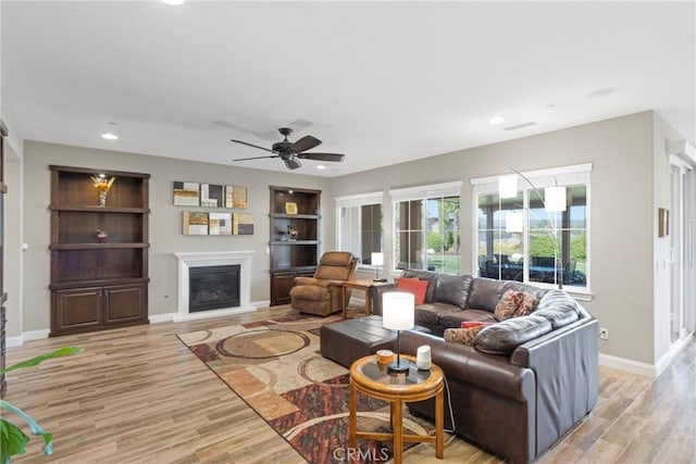 44655 Howell Mountain St, Temecula, CA 92592 - living room featuring a glass covered fireplace, light wood finished floors, ceiling fan, recessed lighting, and built in shelves