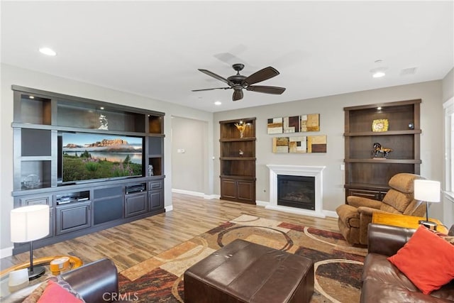 44655 Howell Mountain St, Temecula, CA 92592 - living area with wood finished floors, a ceiling fan, a glass covered fireplace, recessed lighting, and built in features