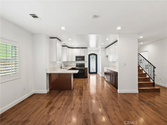 2128 E 3rd St, Los Angeles, CA 90033 - kitchen featuring range, black microwave, light countertops, dark wood-type flooring, and recessed lighting