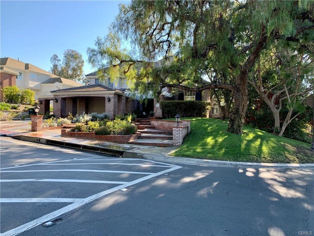 30967 Steeplechase Dr, San Juan Capistrano, CA 92675 - view of front of property featuring uncovered parking, brick siding, and a front lawn