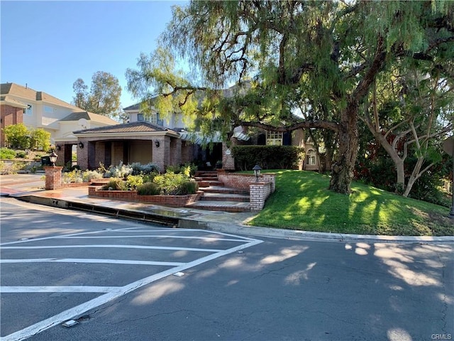 30967 Steeplechase Dr, San Juan Capistrano, CA 92675 - view of front of property featuring uncovered parking, brick siding, and a front lawn