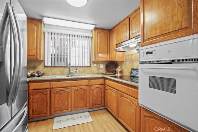 3857 W 135th, Hawthorne, CA 90250 - kitchen featuring freestanding refrigerator, oven, under cabinet range hood, and tasteful backsplash
