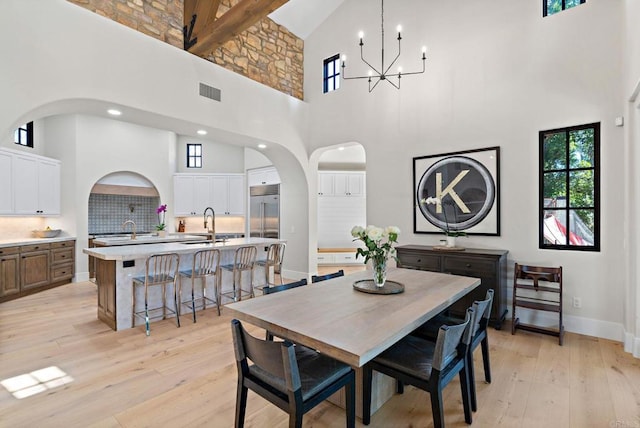 6937 Corte Spagna, Rancho Santa Fe, CA 92091 - dining area featuring high vaulted ceiling, arched walkways, light wood finished floors, and a chandelier