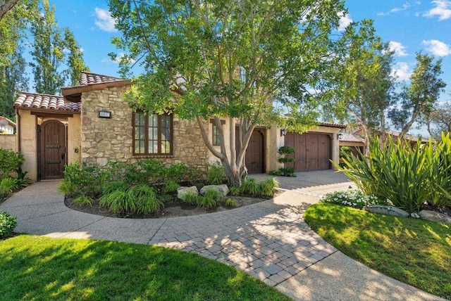6937 Corte Spagna, Rancho Santa Fe, CA 92091 - view of front of property featuring a tile roof, stone siding, stucco siding, driveway, and a garage