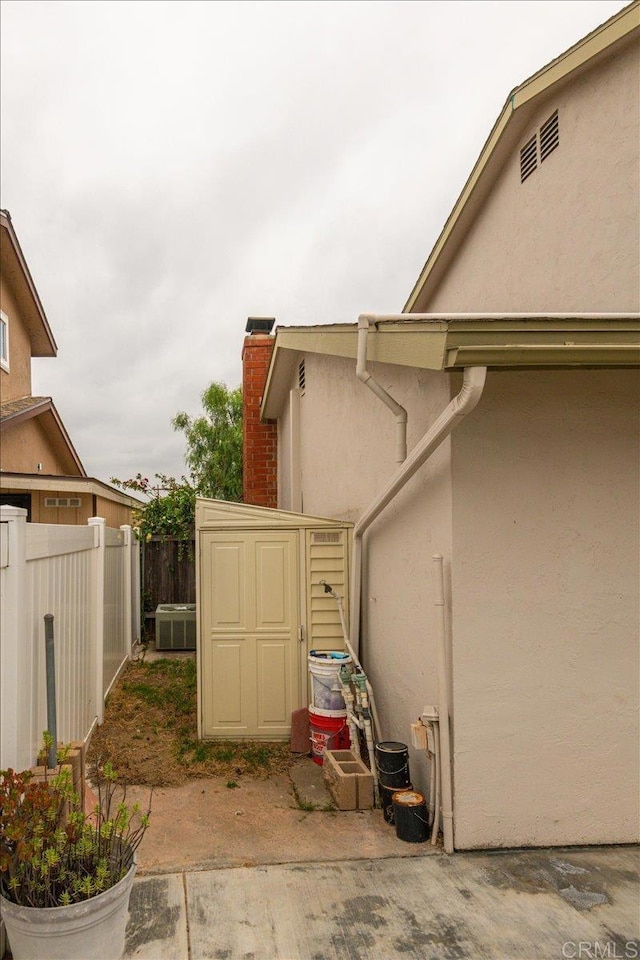 1110 Benjamin Pl, El Cajon, CA 92020 - view of side of home with stucco siding, a storage unit, and a chimney