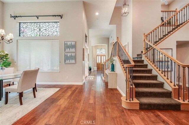 8911 Mustang Rd, Alta Loma, CA 91701 - entryway featuring a towering ceiling, stairway, a chandelier, wood-type flooring, and recessed lighting