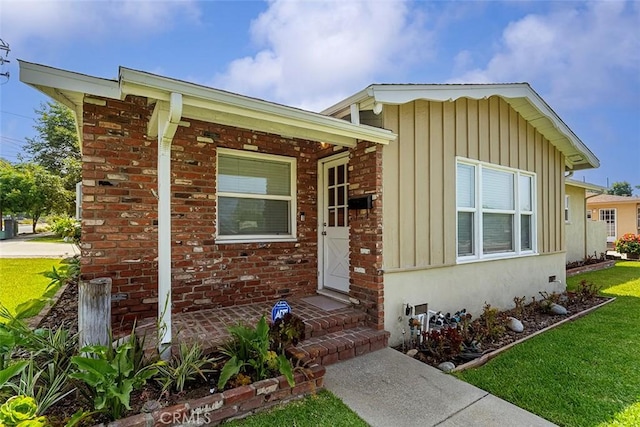 1200 S Pennsylvania Ave, Glendora, CA 91740 - view of front of home featuring board and batten siding, a front yard, and brick siding