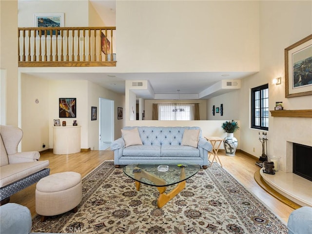 715 W Palm Ave, El Segundo, CA 90245 - living room featuring wood finished floors, healthy amount of natural light, a towering ceiling, and a fireplace