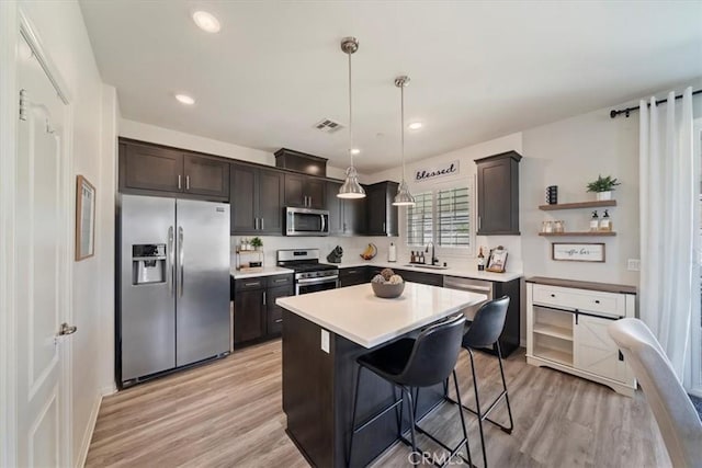 20909 Spring St, Riverside, CA 92507 - kitchen with stainless steel appliances, light wood-style flooring, light countertops, dark brown cabinets, and recessed lighting