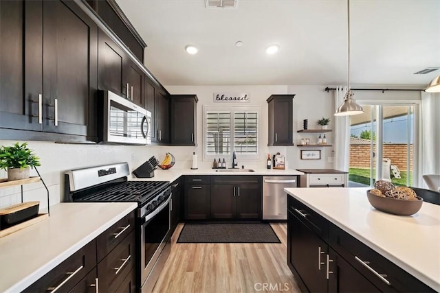 20909 Spring St, Riverside, CA 92507 - kitchen featuring appliances with stainless steel finishes, light wood-type flooring, light countertops, pendant lighting, and recessed lighting