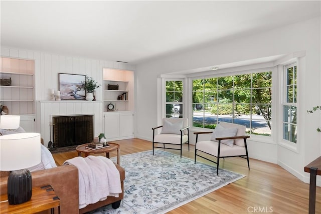 1013 Arbutus Ave, Chico, CA 95926 - living room featuring plenty of natural light, built in shelves, a brick fireplace, and light wood-style flooring