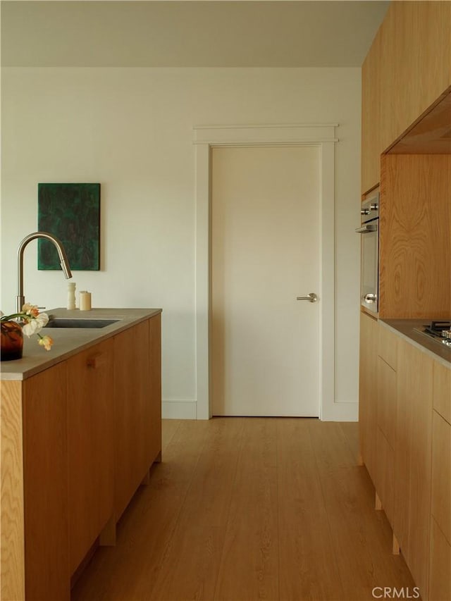 1807 Montana St, Los Angeles, CA 90026 - kitchen with modern cabinets, light brown cabinetry, light wood-style flooring, light countertops, and appliances with stainless steel finishes