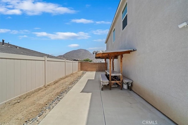 20697 Bison Mesa Rd, Riverside, CA 92507 - fenced backyard with a mountain view and a patio area