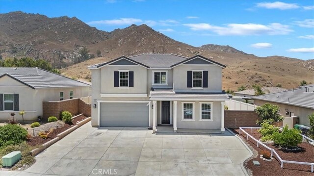 20697 Bison Mesa Rd, Riverside, CA 92507 - traditional-style home featuring a mountain view, stucco siding, a garage, and driveway