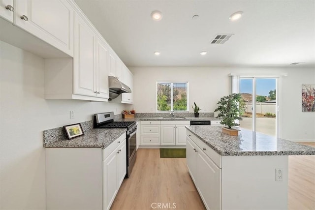 20697 Bison Mesa Rd, Riverside, CA 92507 - kitchen with stainless steel gas stove, under cabinet range hood, light wood finished floors, white cabinets, and a kitchen island