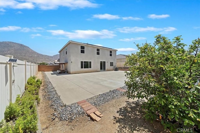 20697 Bison Mesa Rd, Riverside, CA 92507 - back of property with a fenced backyard, a mountain view, stucco siding, and a patio