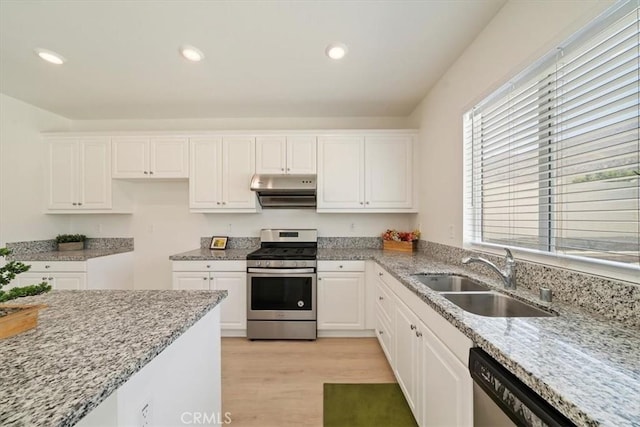 20697 Bison Mesa Rd, Riverside, CA 92507 - kitchen featuring gas range, under cabinet range hood, light stone countertops, light wood-type flooring, and white cabinets
