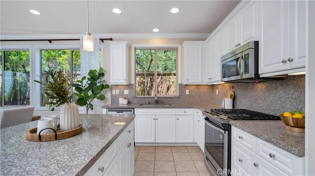 233 Bright Poppy, Irvine, CA 92618 - kitchen featuring appliances with stainless steel finishes, light tile patterned flooring, ornamental molding, white cabinetry, and pendant lighting