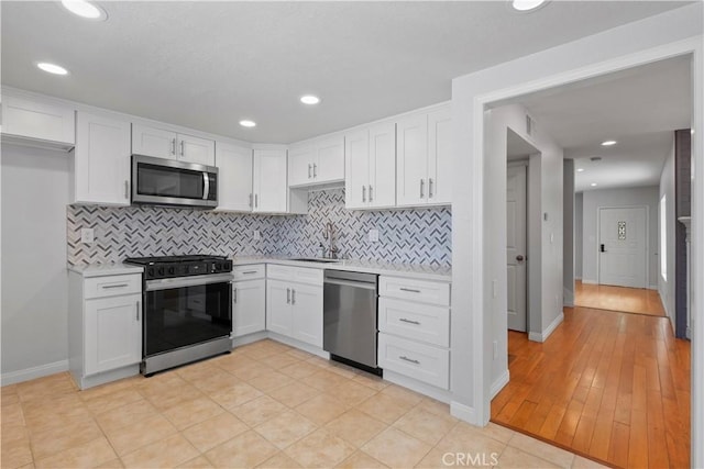 8211 Winnetka Ave Unit 201, Winnetka, CA 91306 - kitchen featuring appliances with stainless steel finishes, light countertops, white cabinets, decorative backsplash, and recessed lighting