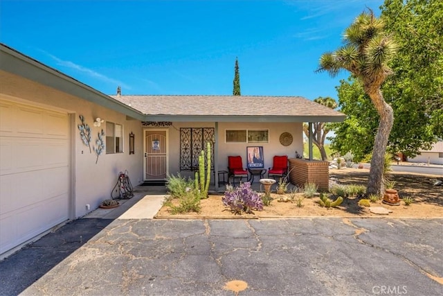 8160 Cholla Ave, Yucca Valley, CA 92284 - view of front of property with stucco siding, a porch, and a garage